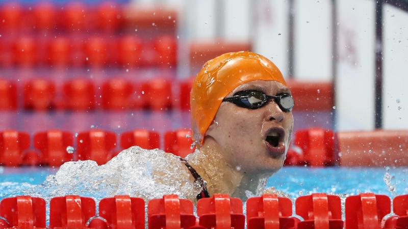 A female swimmer with orange cap in the water
