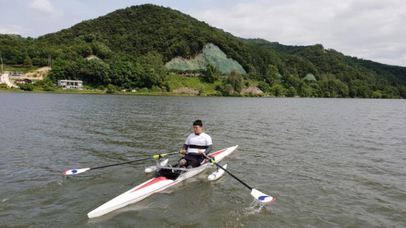 Man on rowing boat with scenic background