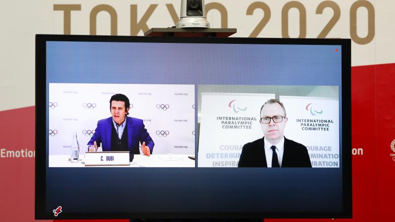 A monitor shows the IOC's Olympic Games Operations Director Pierre Ducrey and IPC's Chief Brand and Communications Officer Craig Spence participating remotely in the Tokyo 2020 Playbooks Press Briefing