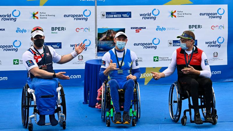 Three men in wheelchairs celebrating their medals