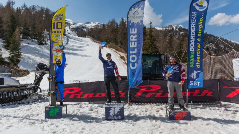 Three male snowboarders on a podium