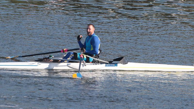 Man celebrates in rowing boat