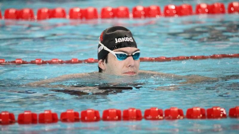 A man with a black cap and the Italian flag in a swimming pool