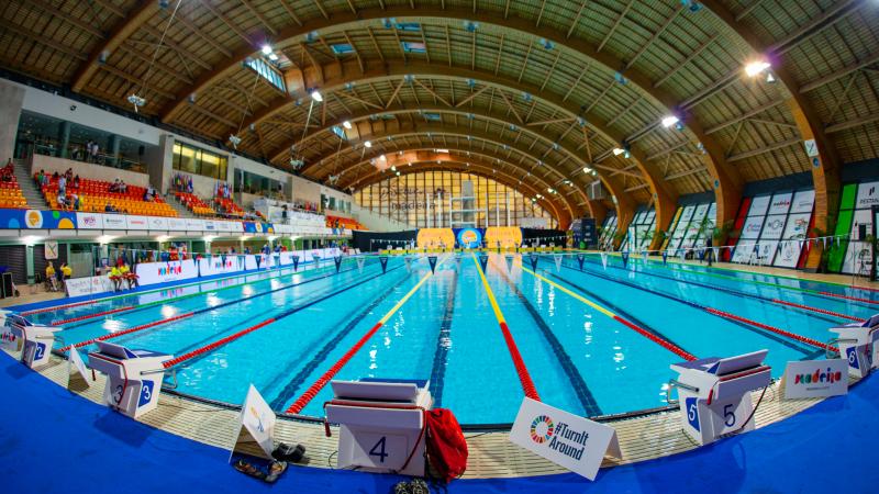 A indoor swimming pool with people watching in the stands