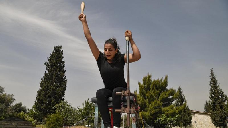 Para athlete on a chair throwing a club