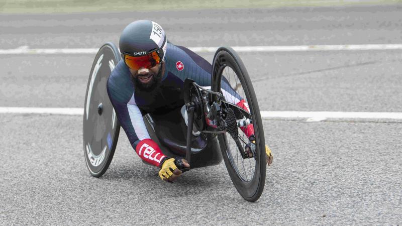 Male handcyclist rounds a corner