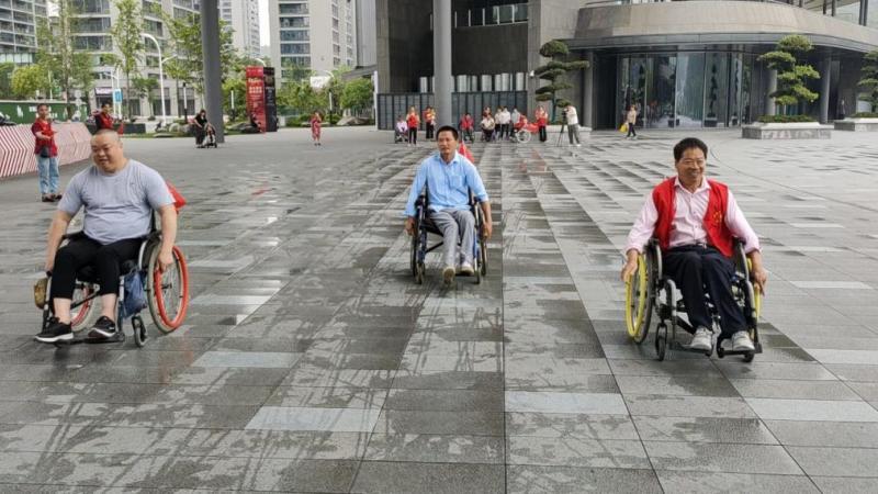 Three men in wheelchairs moving forward