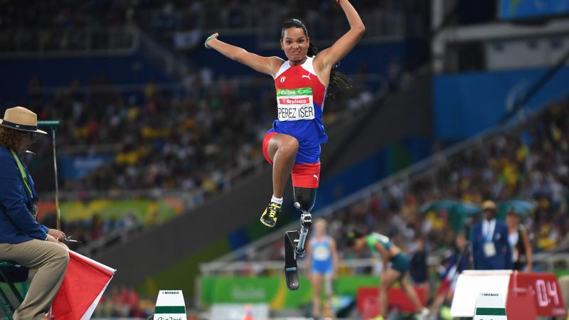 Cuban athlete with a prosthesis in the air after jumping while competing in the long jump