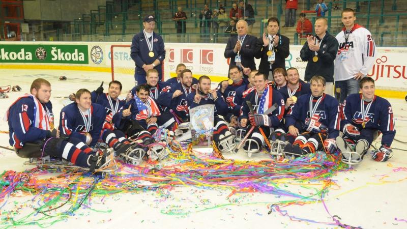 A group of Para ice hockey players with USA uniforms celebrating in an ice rink