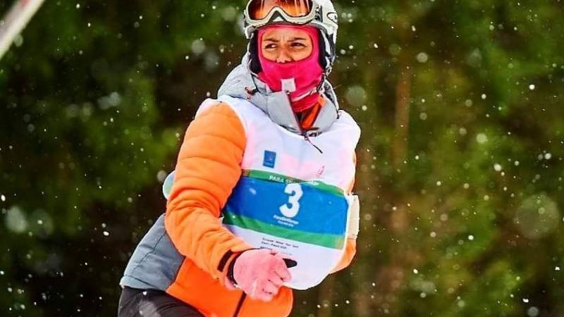 A female Para snowboarder riding with one arm