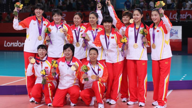 Chinese sitting volleyball team celebrates on the podium after winning gold at London 2012