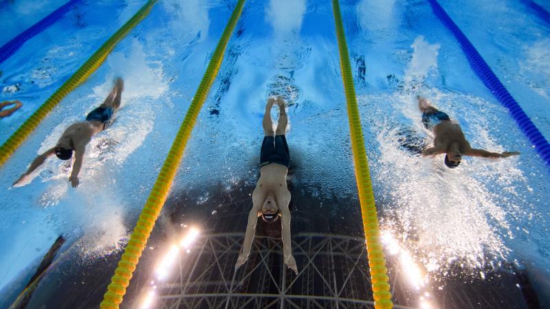 An underwater image of three male Para swimmers