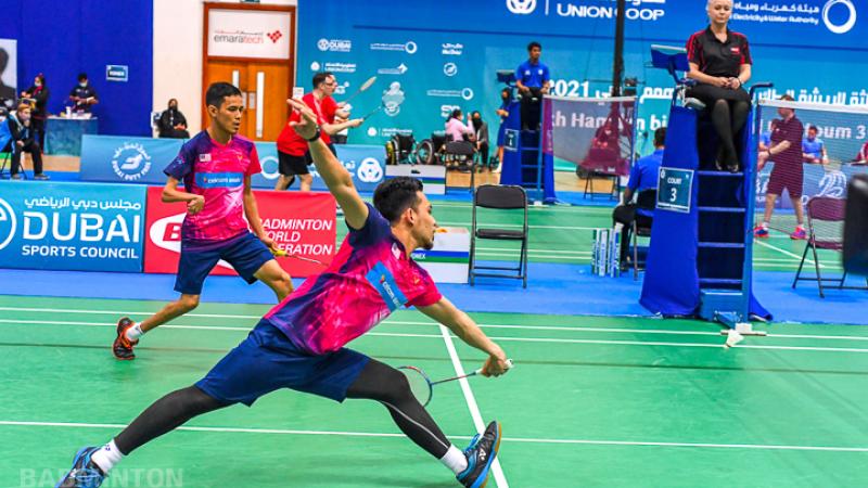 Male athlete reaches for the shuttle while competing in a males doubles team