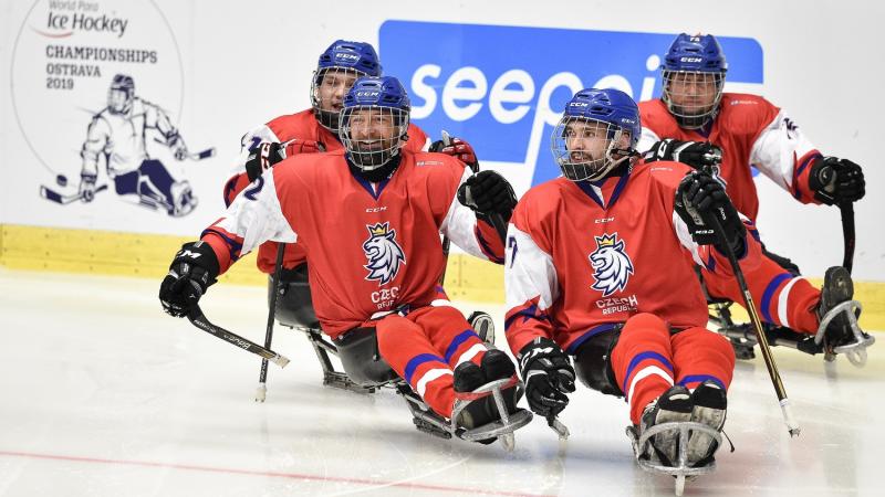 Four Czech Republic Para ice hockey players on an ice rink