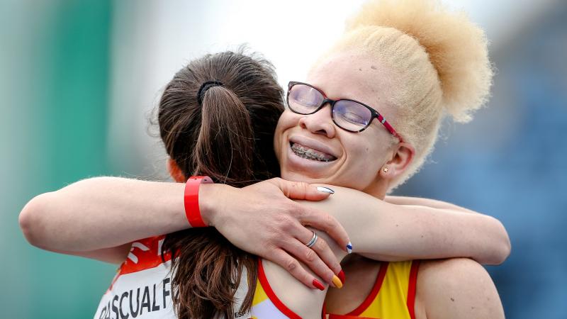 A woman with glasses hugging another woman