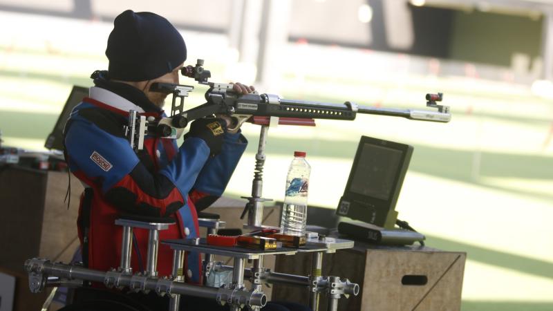 A man with a rifle competing in a shooting range