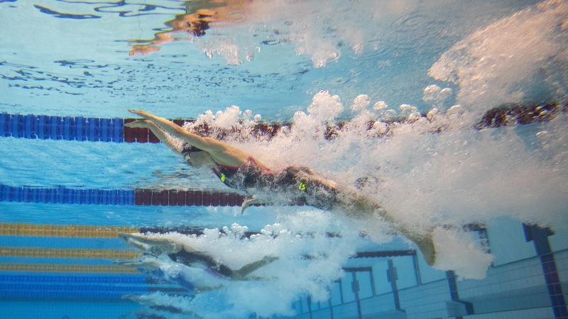 An underwater image of a female swimmer jumping in the water