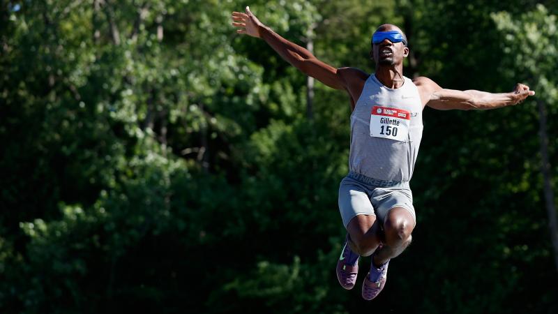 A man blindfolded jumping