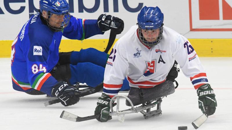 A Slovakian Para ice hockey player followed closely by an Italian player