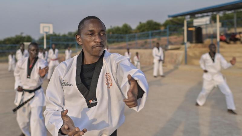 African male taekwondo athlete teaching other students