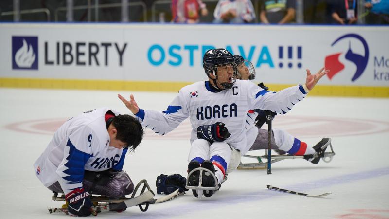Three Para ice hockey players on ice with the uniform of South Korea