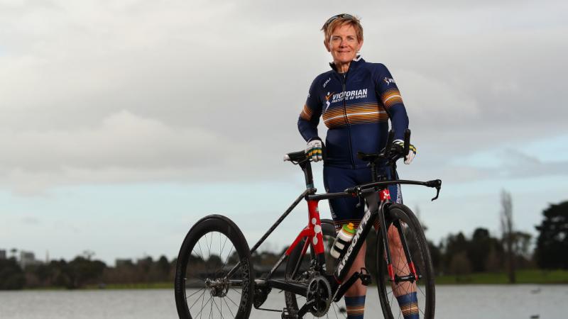 Woman poses next to her tricycle