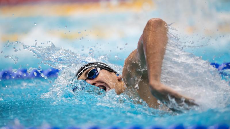 A man swimming freestyle in a pool