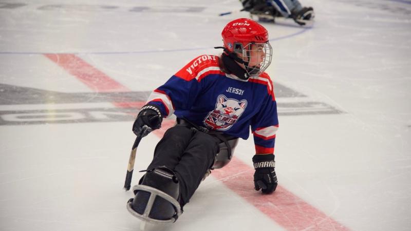 A female Para ice hockey player in a rink