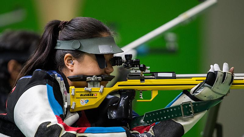 A woman shooting with a rifle in a competition