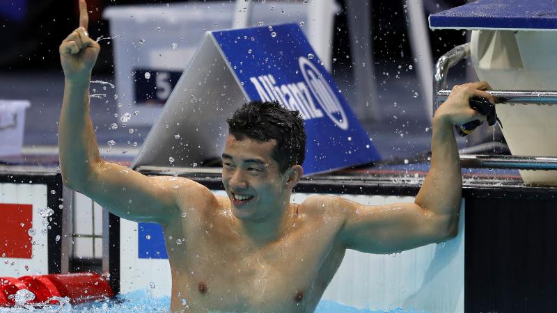 A man celebrating in a swimming pool