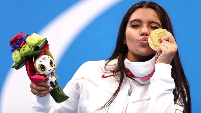 A young woman kissing her gold medal 
