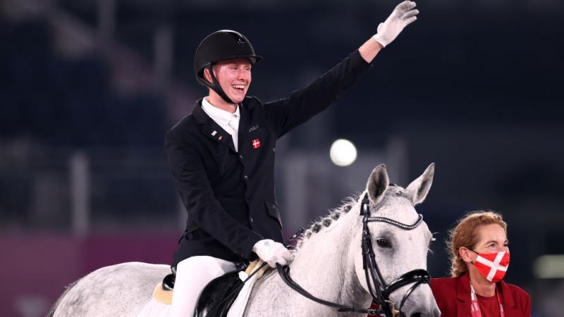  Tobias Thorning Jorgensen on his horse waves his hand in the air and smiles
