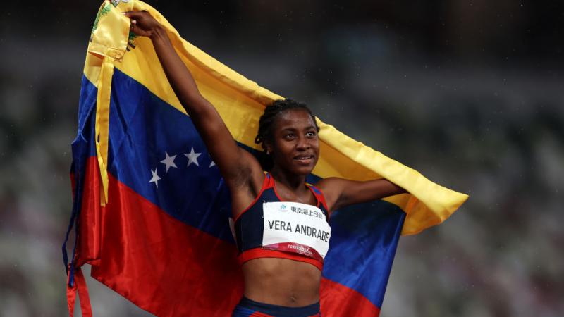 Lisbeli Vera Andrade holds up her country's flag 