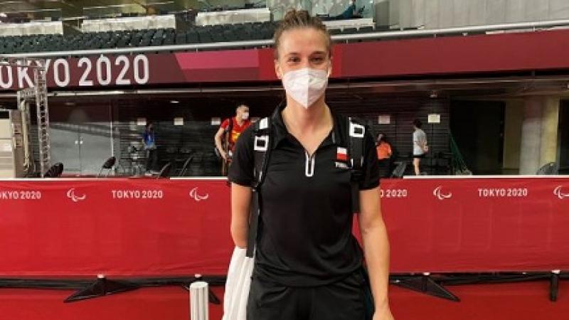 Wearing a white mask and black top and shorts, Natalia Partyka smiles in the press mixed zone