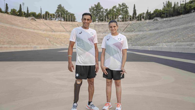 Man and woman stand next to each other with Asics gear