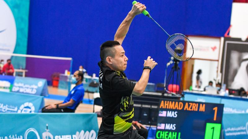 Malaysia's Cheah Liek Hou jumps in the air playing badminton
