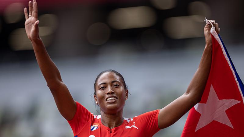 Cuban sprinter Omara Durand holds her coutry's flag and smiles after winning her sixth Paralympic gold