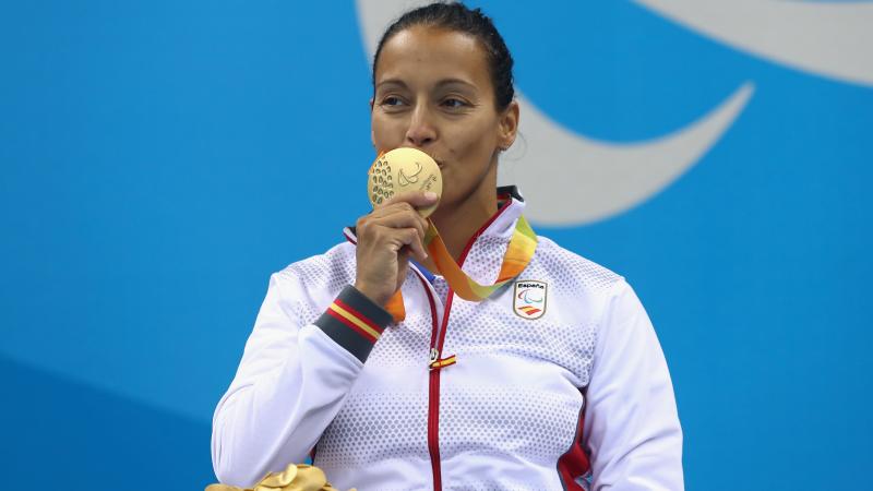 A woman kissing her gold medal