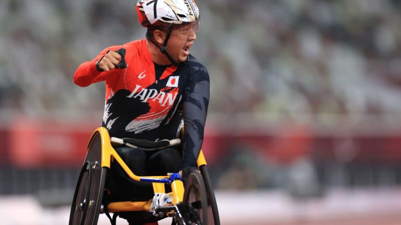 A man in a wheelchair celebrates the victory, putting his fist up