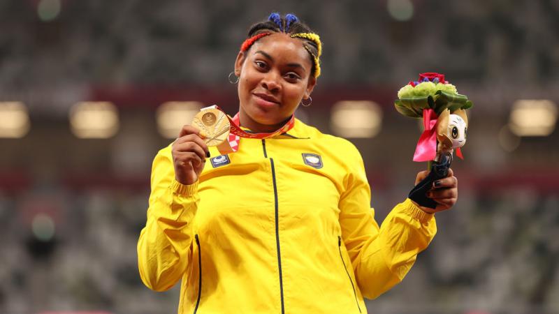 Woman smiles with gold medal around neck