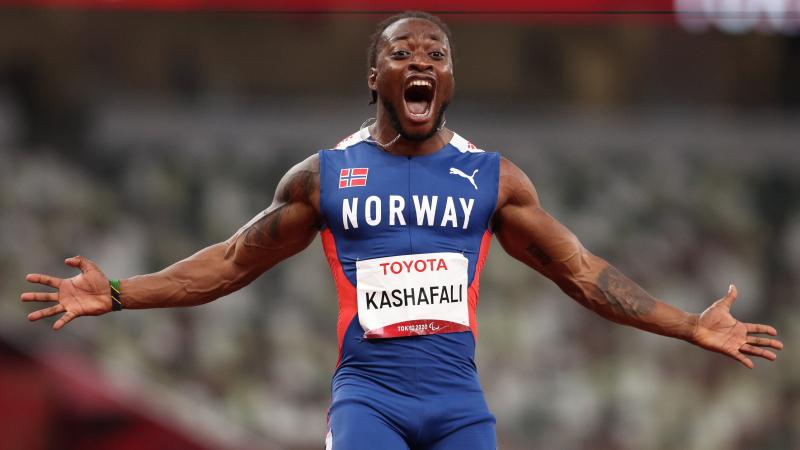 A man celebrates the victory with open arms and a big smile