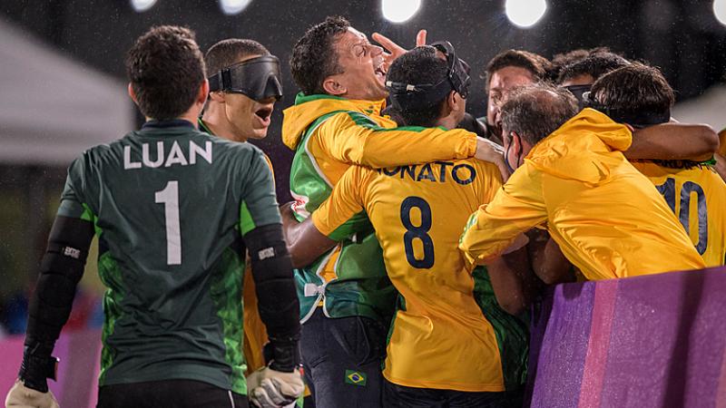 Scorer Nonato is mobbed by team-mates after his goal clinched gold