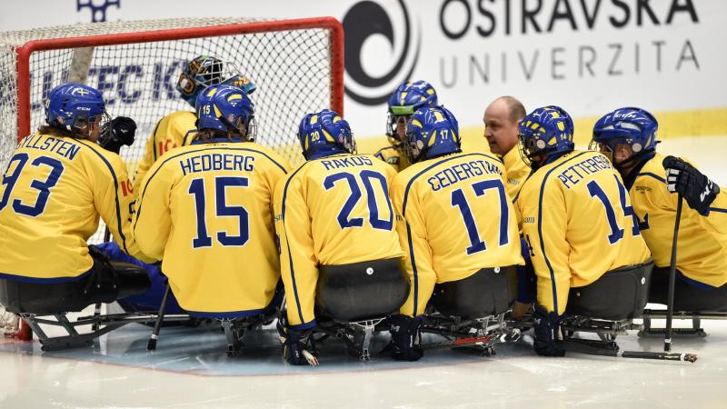 Para ice hockey players making a circle around the goalkeeper before the game