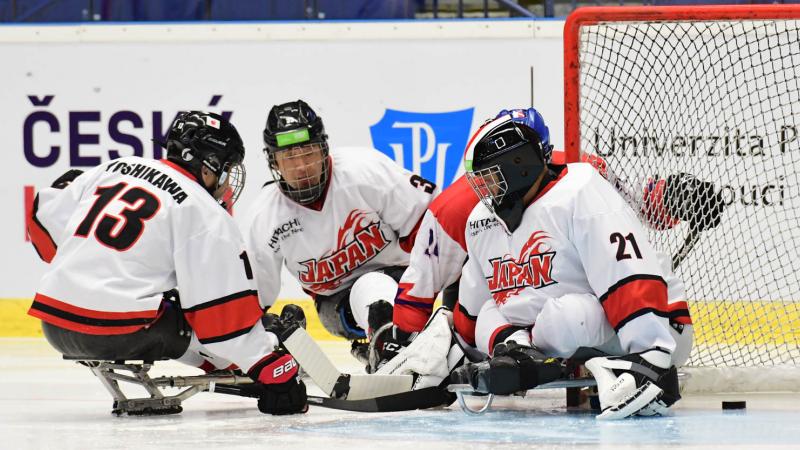 Para ice hockey players trying to find the puck on the ice