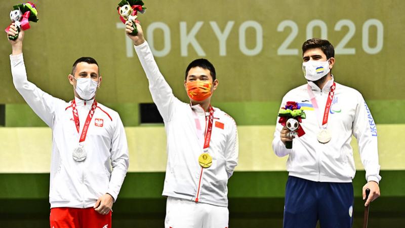 Three men standing on a podium with their medals