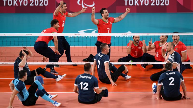 Iranian sitting volleyball team celebrates while Bosnian remains shocked on the other side of the net