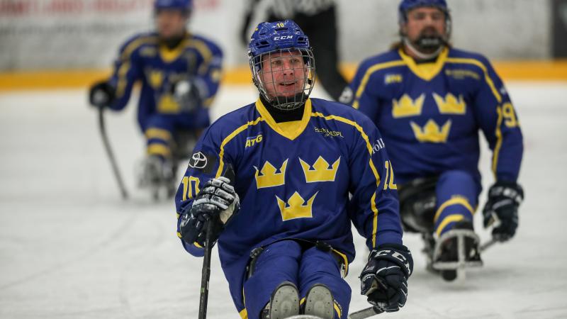 A man skating on a sled and smiling