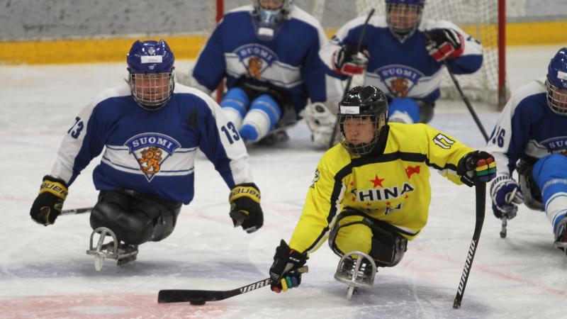 Men chasing the puck on a sled