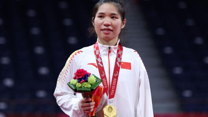 Yang Qiuxia on the podium with gold medal and flowers