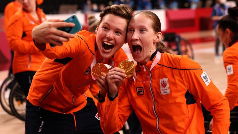 Bo Kramer takes a selfie with Ilse Arts holding their gold medals